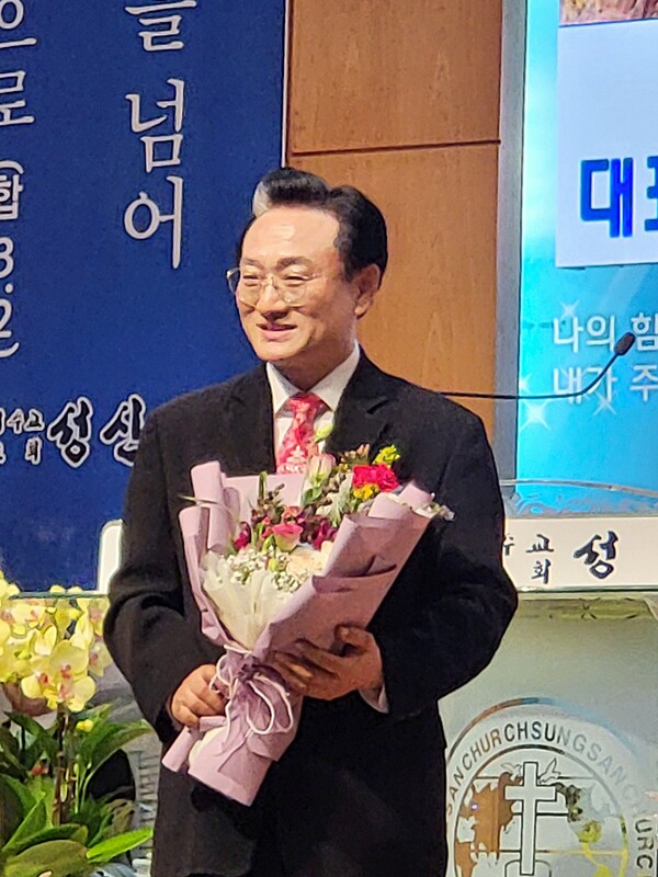 경기총 대표총회장으로 선출된 오범열 목사가 꽃다발을 받는 모습
